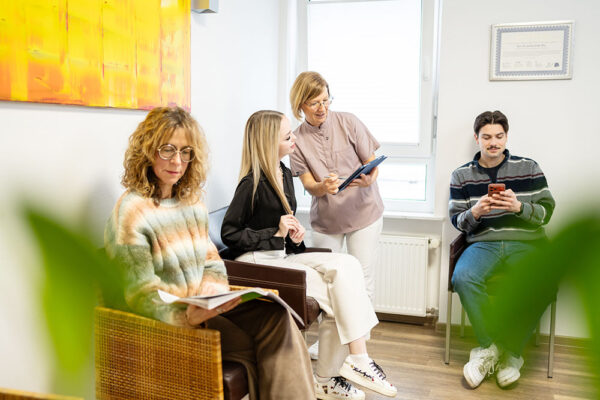 Zahnmedizinische Fachangestellte im Gespräch mit einer Patientin im Wartezimmer der Zahnarztpraxis synerdent in Bruchsal