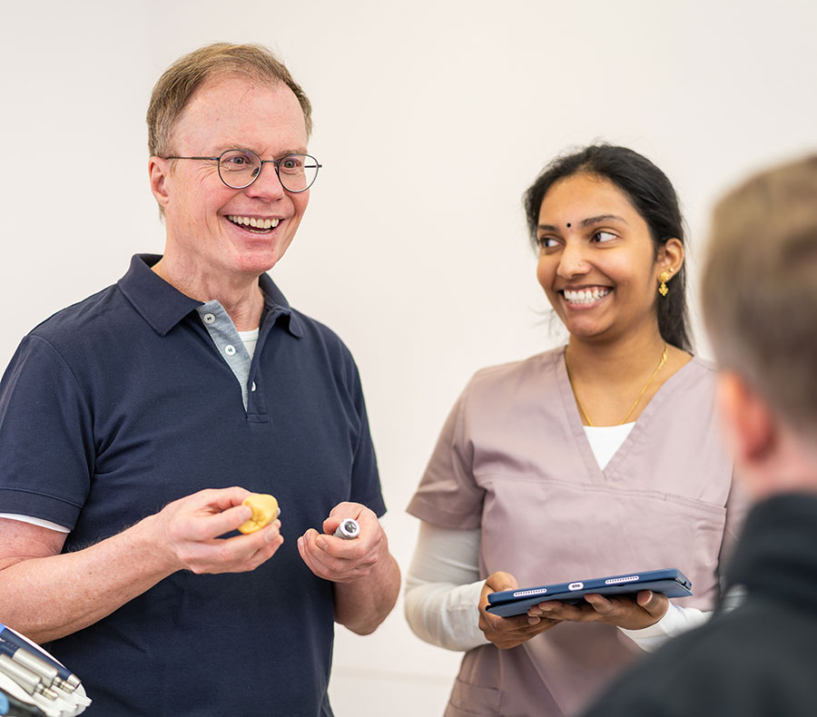 Dr. Jochen Früh zeigt einem Patienten ein Implantatmodell in der Zahnarztpraxis synerdent in Bruchsal